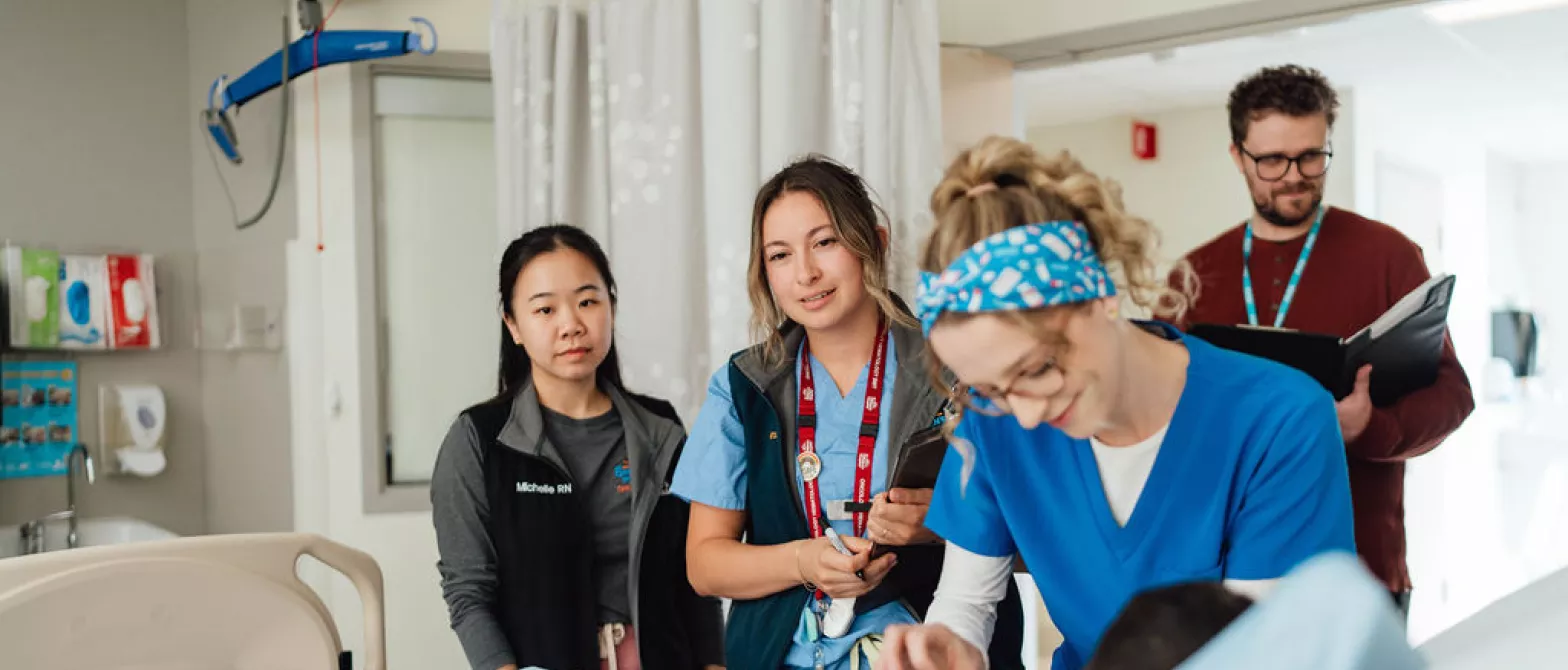 Several staff members at patient bedside