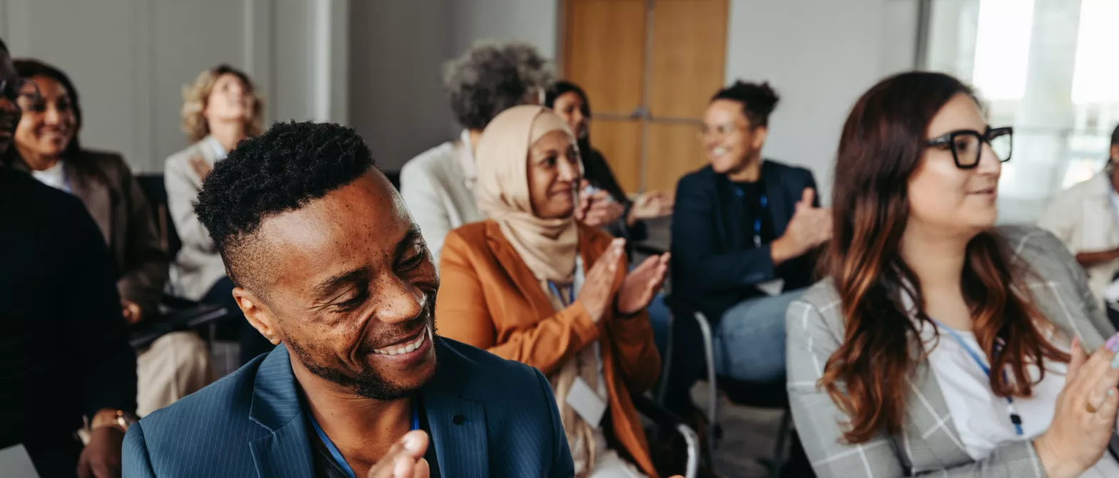 Audience members clapping and smiling