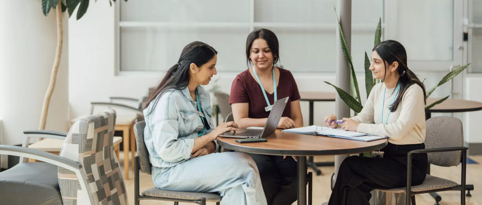 Three employees collaborating around a table.