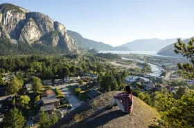 A person on top of a mountain looking over Squamish 
