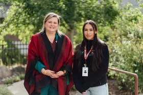 Two members of the Sanya'kula team posing for a photo in nature