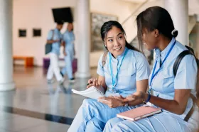 Two young nurses smiling and chatting