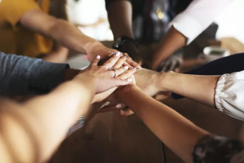 A team stacking their hands to show teamwork