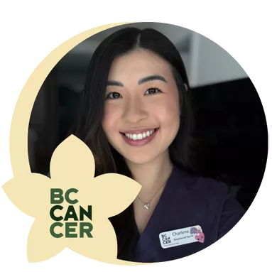 Smiling woman in a purple uniform wearing a name tag