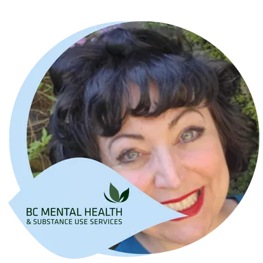 Smiling woman with curly dark hair and red lipstick stands outdoors